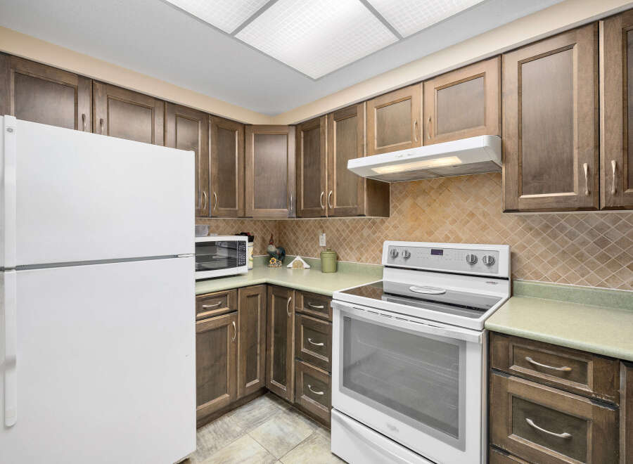 This charming kitchen features beautiful wooden cabinetry, offering ample storage and a warm, inviting atmosphere.