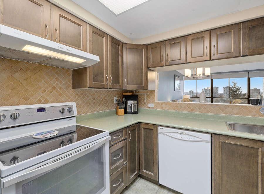This kitchen features a modern design with ample cabinet space and a sleek countertop.