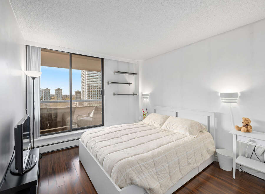 This bright and airy bedroom offers a serene retreat with its neutral color palette and ample natural light.