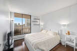This bright and airy bedroom offers a serene retreat with its neutral color palette and ample natural light.