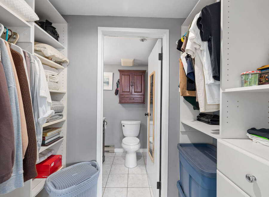 Step into this well-organized walk-in closet, offering ample storage and a seamless transition into the adjacent bathroom.