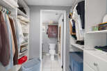 Step into this well-organized walk-in closet, offering ample storage and a seamless transition into the adjacent bathroom.