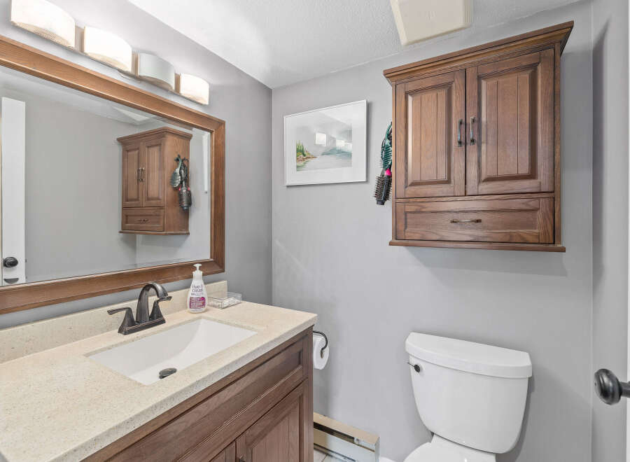 This bathroom features a stylish vanity with a sink and a large mirror, perfect for daily routines.