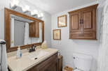 This bathroom features a stylish vanity with a sink, complemented by a large mirror and elegant lighting fixtures.