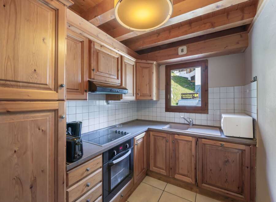 This charming kitchen features wooden cabinetry and a cozy ambiance, perfect for preparing meals.