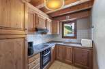 This charming kitchen features wooden cabinetry and a cozy ambiance, perfect for preparing meals.