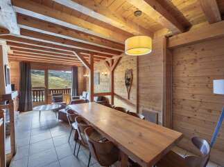 Experience the charm of this stunning property, featuring a spacious dining area with a large wooden table, perfect for gatherings.