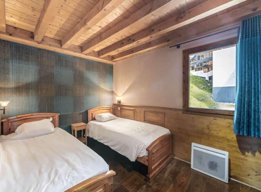 This cozy bedroom features two twin beds with crisp white linens, perfect for a comfortable stay.