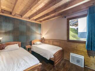 This cozy bedroom features two twin beds with crisp white linens, perfect for a comfortable stay.