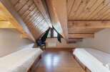 Discover the charm of this unique attic bedroom, featuring exposed wooden beams and a cozy atmosphere.