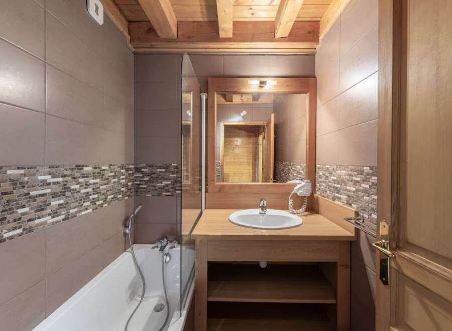 Step into this beautifully designed bathroom, featuring a stylish combination of wood and tile.
