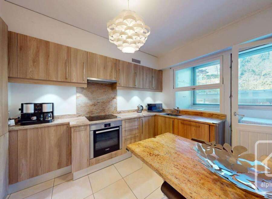 This stunning kitchen boasts a modern design with sleek wooden cabinetry and granite countertops, creating a warm and inviting atmosphere.