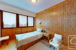 Discover the charm of this cozy bedroom featuring wooden paneling and a comfortable single bed.