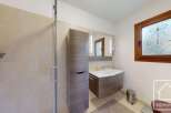 This modern bathroom features a stylish vanity with a sleek design, complemented by a large mirror and built-in lighting.