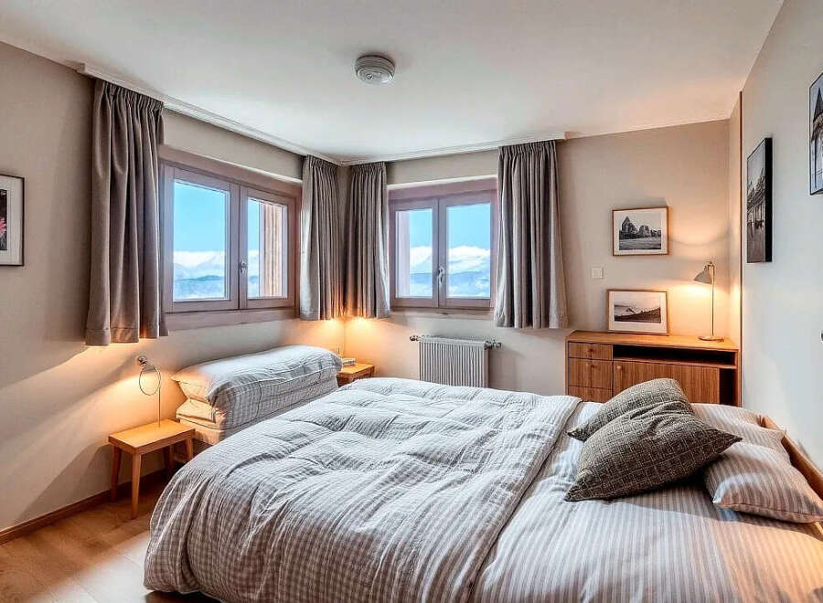 Experience the tranquility of this charming bedroom, featuring stunning mountain views through large windows.