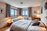 Experience the tranquility of this charming bedroom, featuring stunning mountain views through large windows.