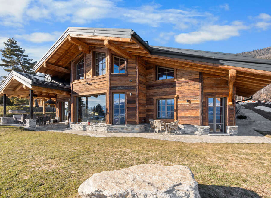 Experience luxury mountain living in this stunning timber-frame chalet, boasting expansive windows that frame breathtaking alpine views.