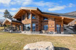 Experience luxury mountain living in this stunning timber-frame chalet, boasting expansive windows that frame breathtaking alpine views.