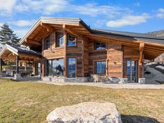 Experience luxury mountain living in this stunning timber-frame chalet, boasting expansive windows that frame breathtaking alpine views.
