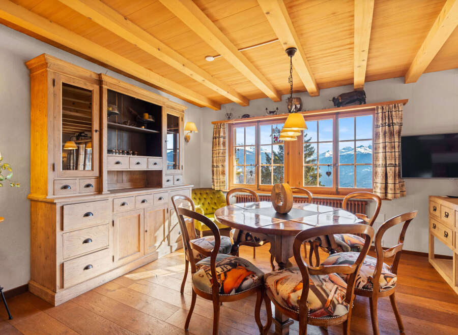 Experience the charm of this exquisite dining room, featuring a rustic wooden table and chairs, perfect for intimate gatherings.