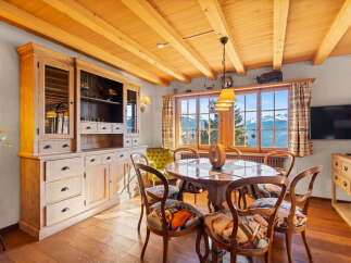 Experience the charm of this exquisite dining room, featuring a rustic wooden table and chairs, perfect for intimate gatherings.