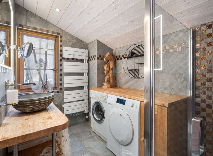 Discover the charm of this unique bathroom design, featuring a rustic wooden countertop and a stylish stone sink.