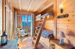 Experience the charm of this cozy cabin bedroom, perfect for a mountain getaway.
