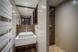 This modern bathroom features a sleek design with a floating sink and a walk-in shower.