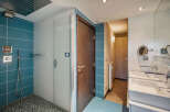 Step into this modern bathroom, featuring a sleek glass shower enclosure and stylish blue tile accents.