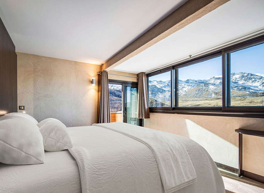 Experience breathtaking mountain views from this luxurious bedroom.