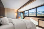 Experience breathtaking mountain views from this luxurious bedroom.