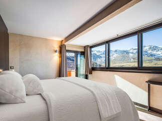 Experience breathtaking mountain views from this luxurious bedroom.