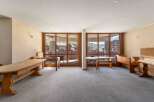 This spacious room offers stunning mountain views through large windows, creating a bright and inviting atmosphere.
