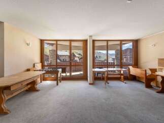 This spacious room offers stunning mountain views through large windows, creating a bright and inviting atmosphere.