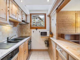 This charming kitchen boasts a warm, inviting ambiance with its wooden cabinetry and countertops.