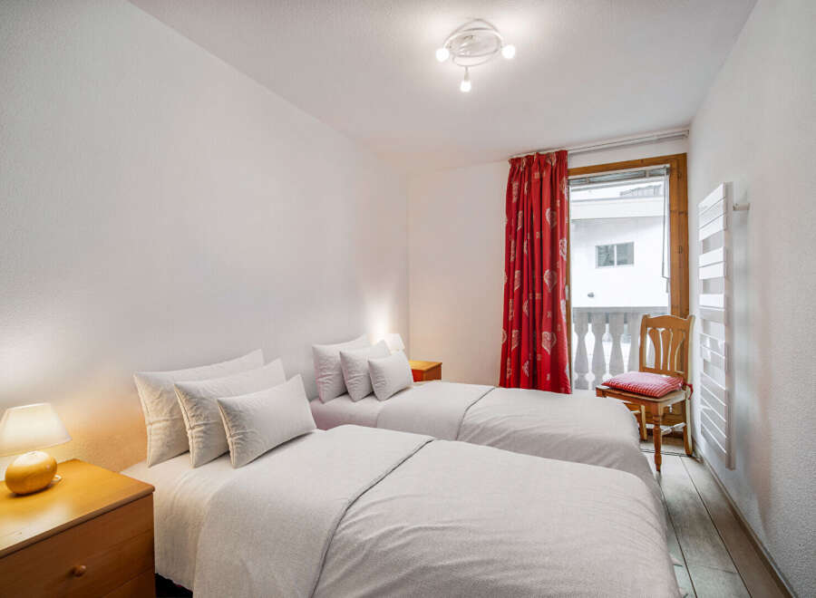 This cozy bedroom features two twin beds, perfect for guests or roommates.