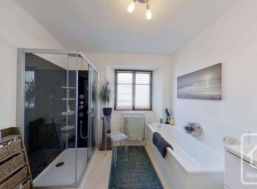 Step into this luxurious bathroom, featuring a sleek glass shower and a relaxing bathtub.