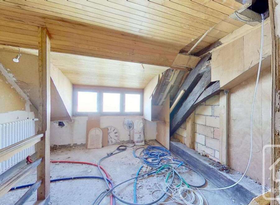 This property features a spacious interior with exposed wooden beams and a unique architectural design.