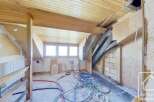 This property features a spacious interior with exposed wooden beams and a unique architectural design.