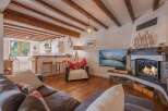 Experience the warmth and charm of this cozy living space, featuring a stunning fireplace and exposed wooden beams.