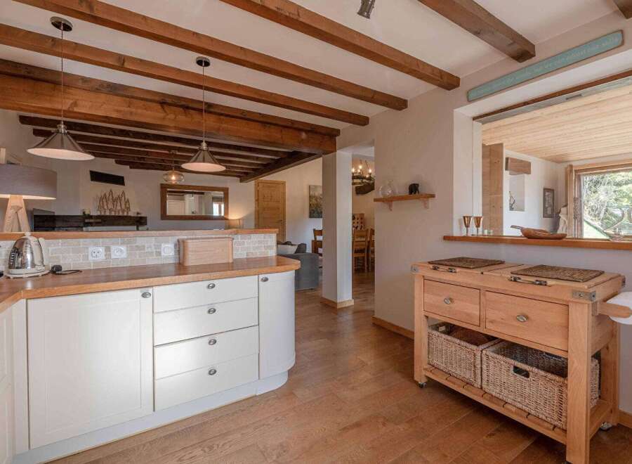 Step into this stunning kitchen, boasting a warm and inviting atmosphere with its wooden beams and cabinetry.