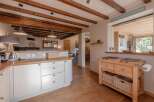 Step into this stunning kitchen, boasting a warm and inviting atmosphere with its wooden beams and cabinetry.