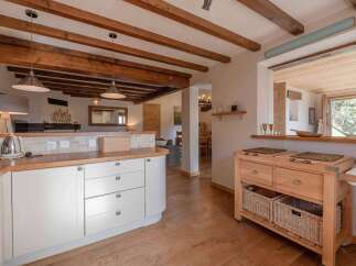 Step into this stunning kitchen, boasting a warm and inviting atmosphere with its wooden beams and cabinetry.