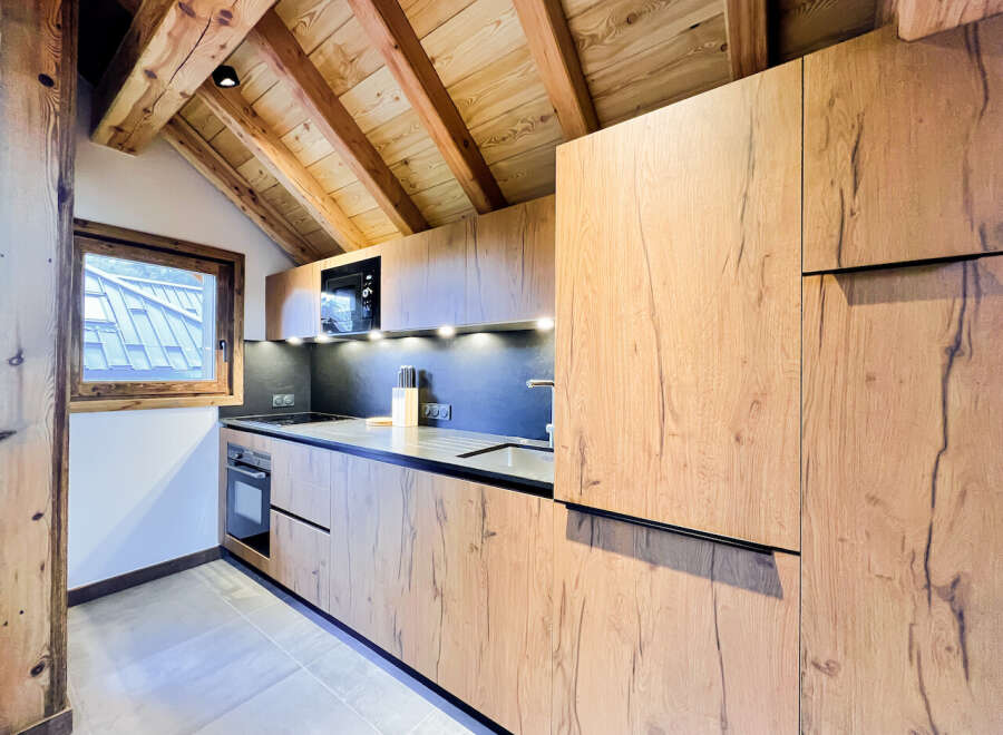 This stunning kitchen boasts a modern design with beautiful wooden cabinetry and a sleek countertop.