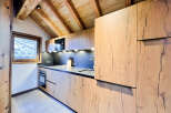 This stunning kitchen boasts a modern design with beautiful wooden cabinetry and a sleek countertop.