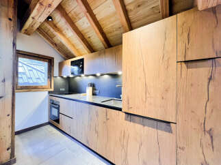 This stunning kitchen boasts a modern design with beautiful wooden cabinetry and a sleek countertop.