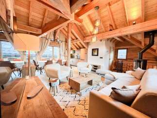 Experience the warmth of this stunning chalet, featuring exposed wooden beams and a cozy fireplace.