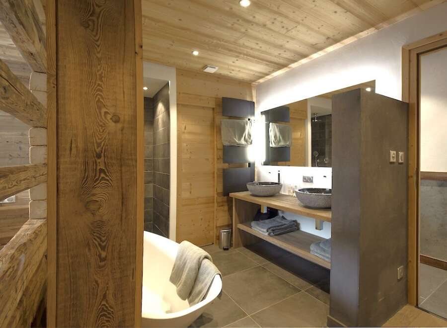 This luxurious bathroom boasts a rustic, yet modern design, perfect for a relaxing retreat.