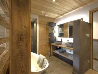 This luxurious bathroom boasts a rustic, yet modern design, perfect for a relaxing retreat.