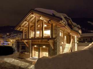 Experience the charm of this stunning wooden chalet nestled in a snowy landscape.